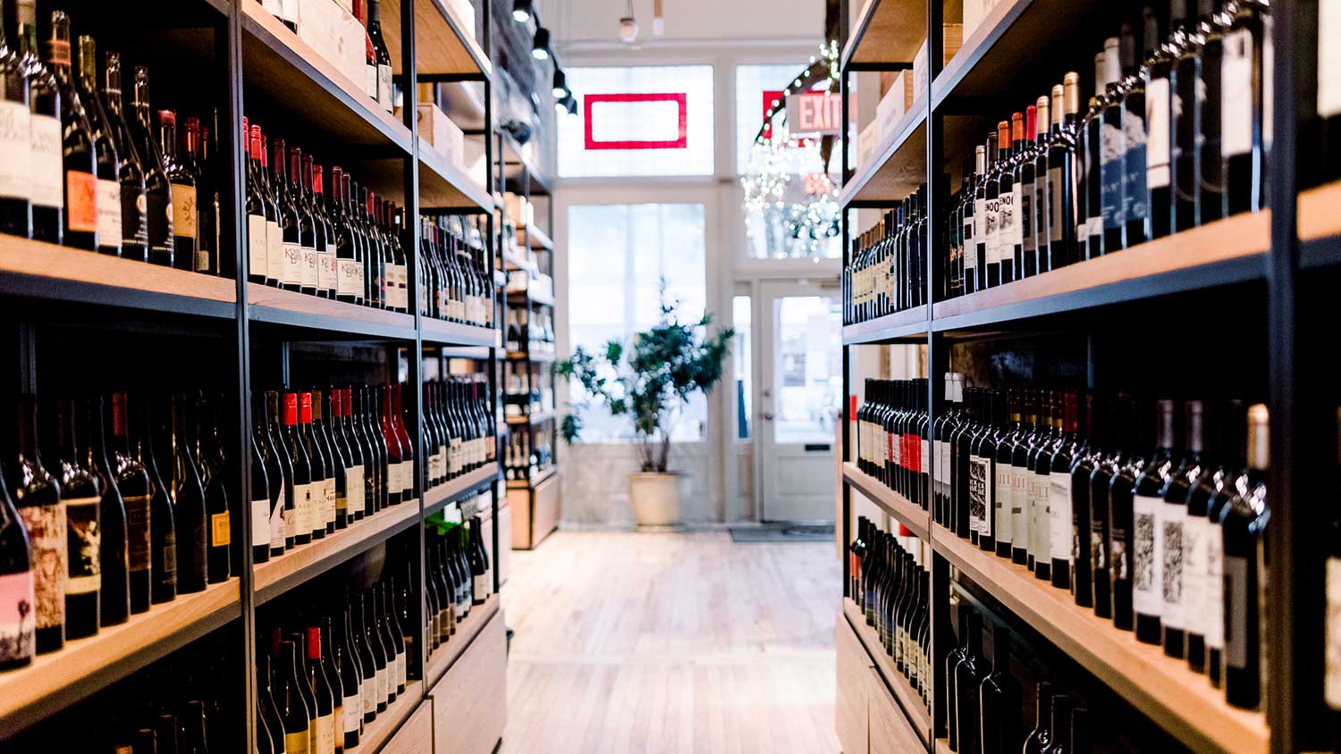 Vertical shelves display wines on the left and right side in the Foxcroft Greenville's wine shop section