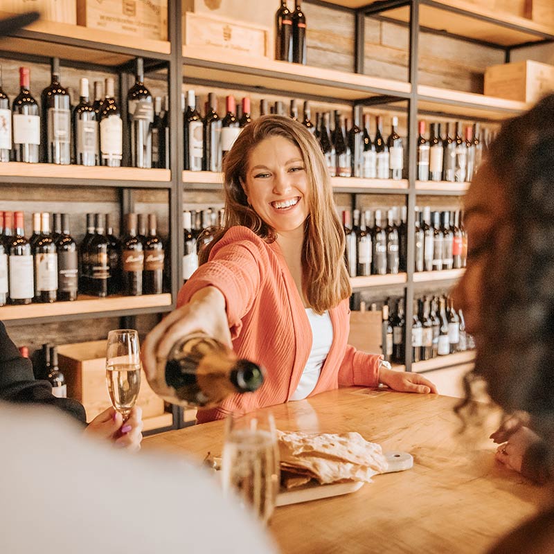 Woman pouring champagne into two guest's flutes