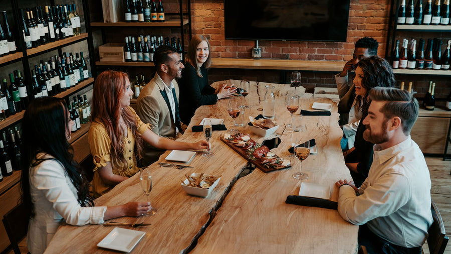 Group of people at a table with a charcuterie board and glasses of wine in the private events room at Foxcroft Greenville