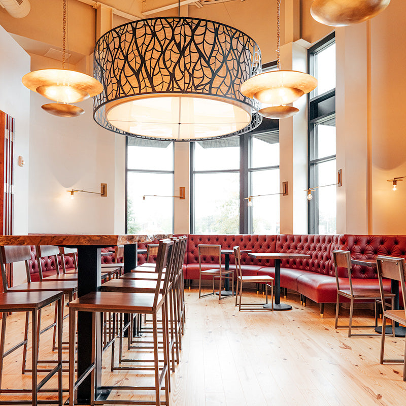 The Modern interior of Foxcroft Waverly with wood tables, chairs, red booths and decorative lighting.