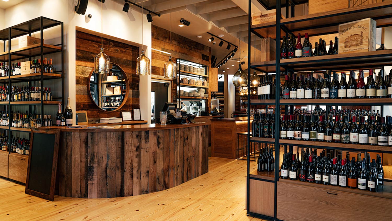 The host stand at Foxcroft Waverly's entrance with vertical wine shelves in the foreground