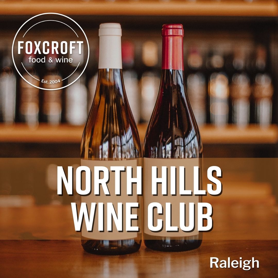 Two wine bottles on a bar with 'Foxcroft food & wine' and 'North Hills Wine Club Raleigh' text.